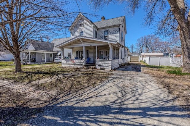 109 S Saint John St, Assumption, IL 62510 - view of front of house featuring fence, covered porch, a chimney, an outdoor structure, and driveway