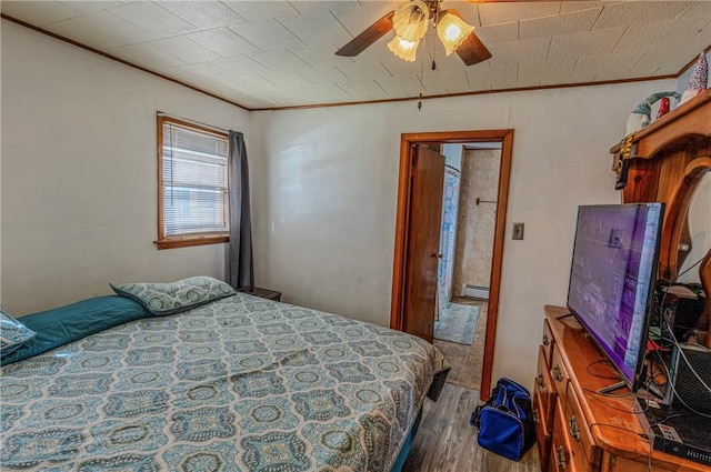 109 S Saint John St, Assumption, IL 62510 - bedroom with ceiling fan, a baseboard radiator, wood finished floors, and crown molding