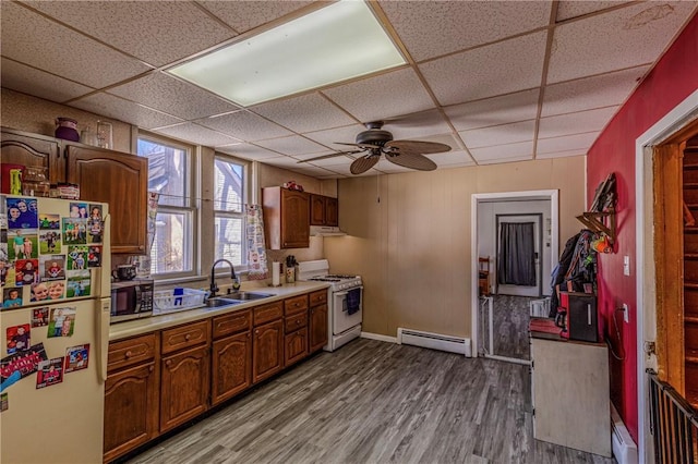 109 S Saint John St, Assumption, IL 62510 - kitchen with a baseboard heating unit, light countertops, wood finished floors, white appliances, and a sink