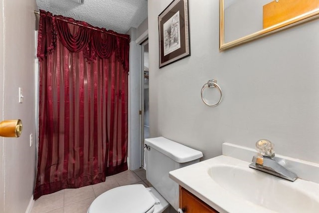 bathroom with tile patterned flooring, vanity, a textured ceiling, and toilet