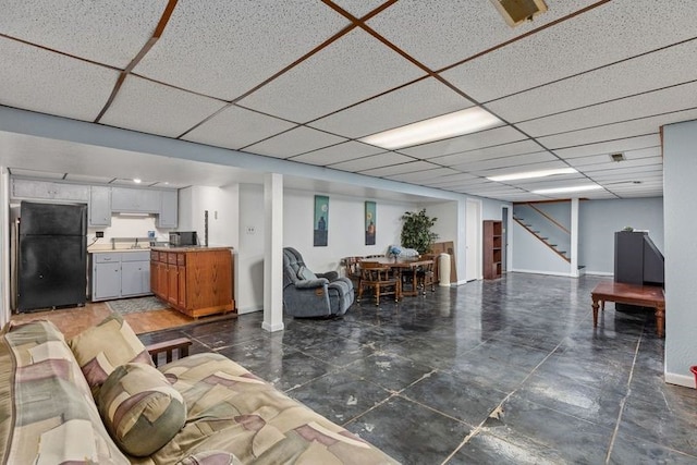 living room featuring a drop ceiling and sink