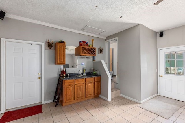 kitchen with a textured ceiling, light tile patterned flooring, and sink