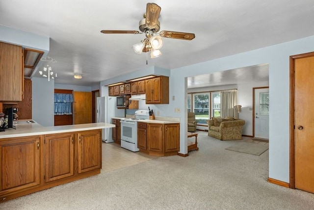 kitchen featuring kitchen peninsula, light carpet, white appliances, and sink