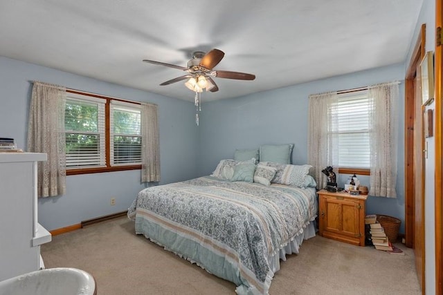 carpeted bedroom featuring multiple windows and ceiling fan