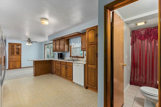 kitchen featuring kitchen peninsula, white dishwasher, ceiling fan, and sink