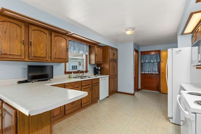 kitchen with white appliances, kitchen peninsula, and sink