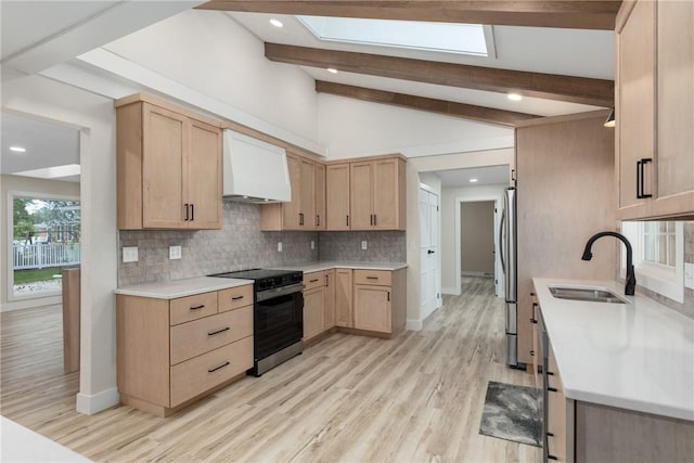 kitchen with electric stove, a sink, light brown cabinets, a skylight, and recessed lighting