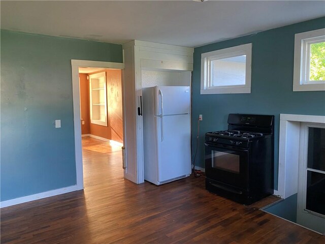 605 W Reynolds St, Newton, IL 62448 - kitchen with freestanding refrigerator, black gas range, and dark wood-type flooring