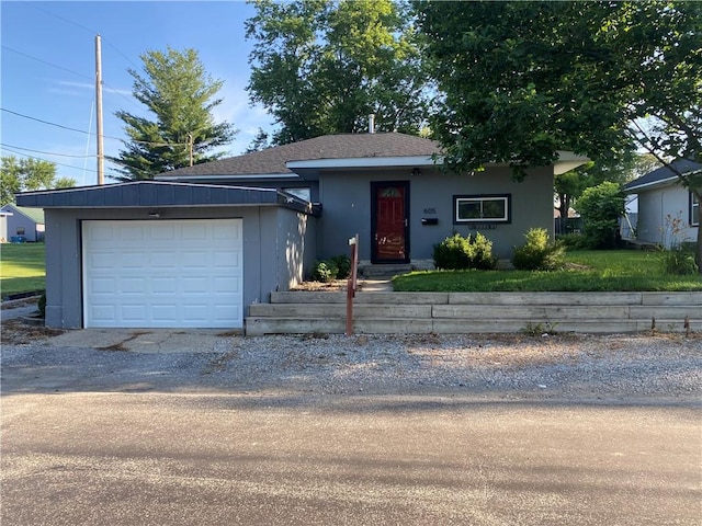 605 W Reynolds St, Newton, IL 62448 - view of front of home featuring driveway, a garage, stucco siding, and a shingled roof