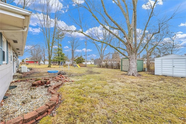 view of yard with a playground and a storage shed