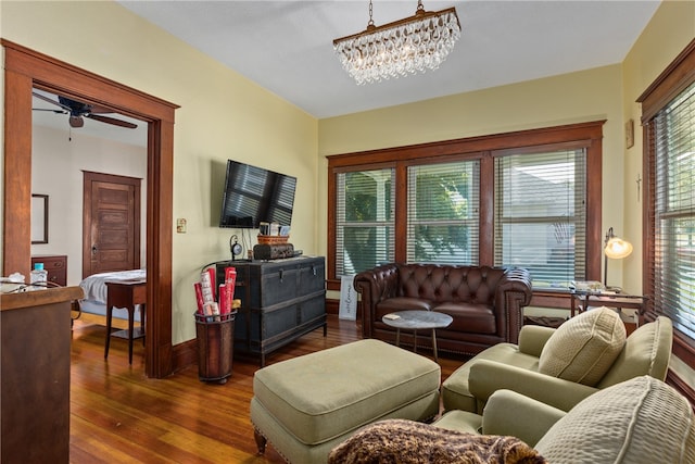 living room featuring plenty of natural light, dark hardwood / wood-style flooring, and ceiling fan with notable chandelier