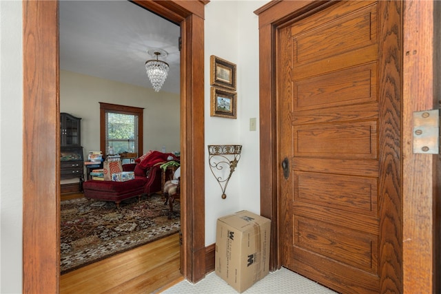 hallway featuring hardwood / wood-style floors and a notable chandelier