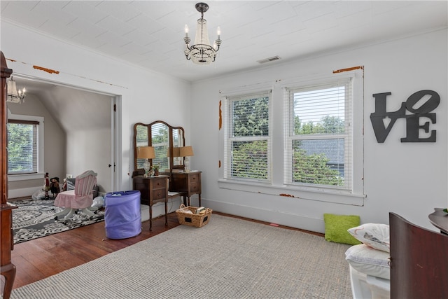 interior space with a chandelier, lofted ceiling, hardwood / wood-style flooring, and ornamental molding