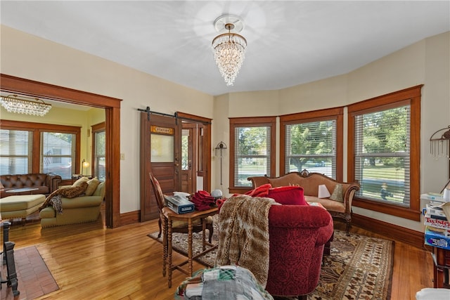 living room with a chandelier, a healthy amount of sunlight, and light wood-type flooring