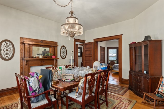 dining area featuring light hardwood / wood-style floors and an inviting chandelier