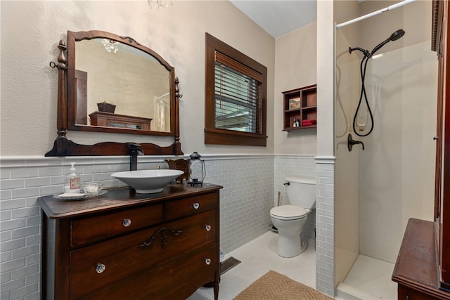 bathroom featuring toilet, vanity, tile walls, and walk in shower