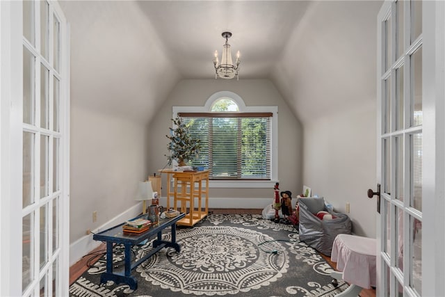 living area with a notable chandelier, wood-type flooring, lofted ceiling, and french doors