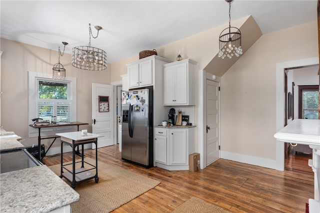 kitchen featuring white cabinets, stainless steel appliances, a chandelier, and hanging light fixtures