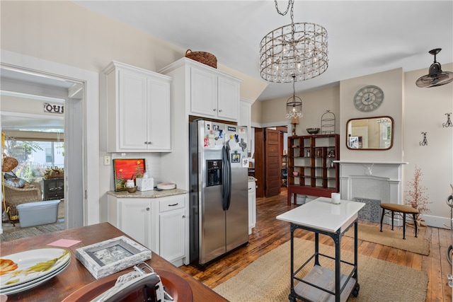 kitchen featuring white cabinets, stainless steel fridge with ice dispenser, dark hardwood / wood-style floors, and hanging light fixtures