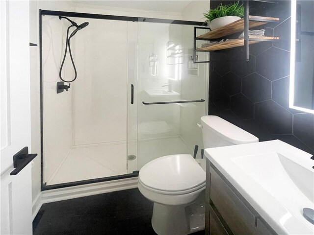 full bathroom featuring a stall shower, vanity, toilet, and tile walls