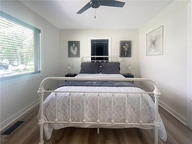 bedroom featuring dark wood-type flooring, visible vents, ceiling fan, and baseboards