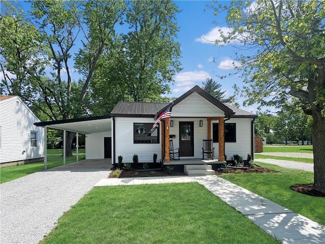 view of front of property with a carport, covered porch, driveway, and a front lawn