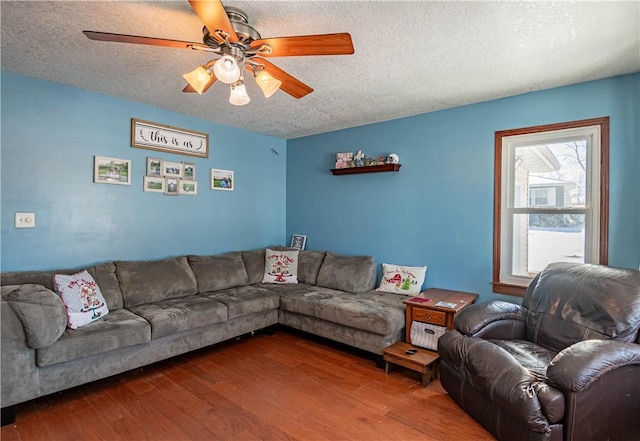 living room with hardwood / wood-style floors, ceiling fan, and a textured ceiling