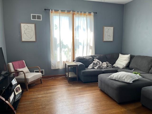 living room featuring visible vents and wood finished floors