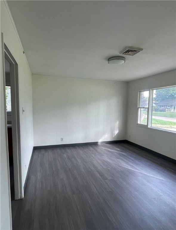 unfurnished room with dark hardwood / wood-style flooring