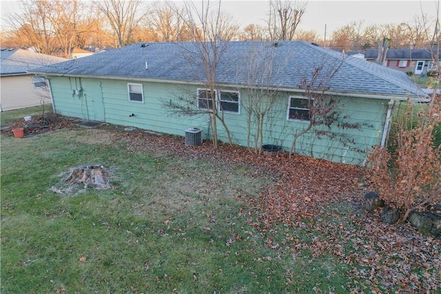 back of house featuring cooling unit and a lawn