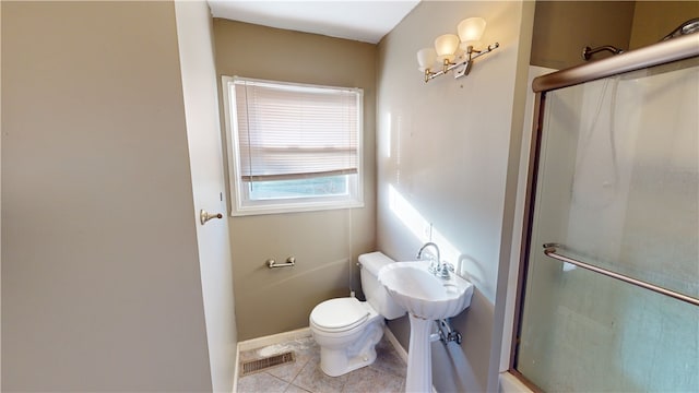 bathroom with tile patterned floors, toilet, and an enclosed shower