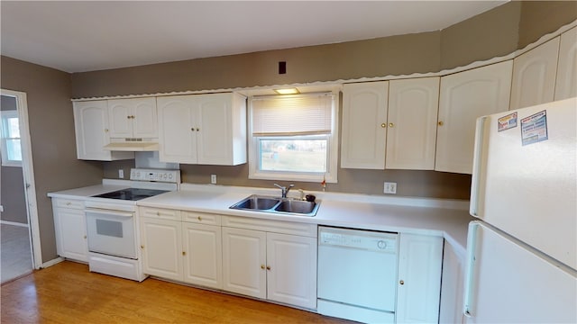 kitchen with white appliances, exhaust hood, sink, white cabinets, and light hardwood / wood-style floors