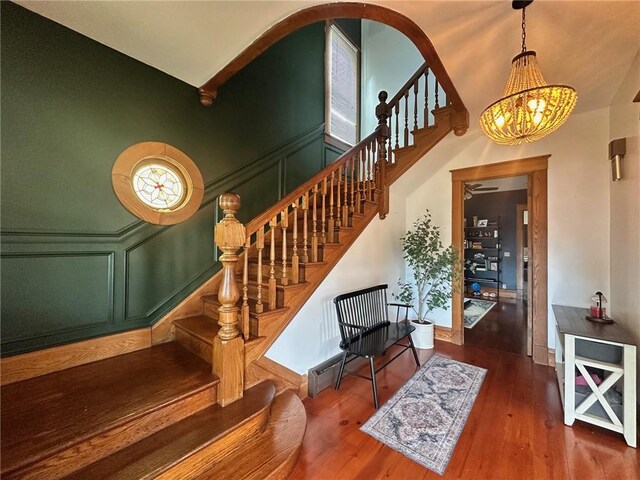 2821 Western Ave, Mattoon, IL 61938 - staircase with a chandelier, wood finished floors, arched walkways, and a decorative wall