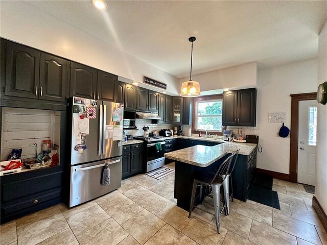 2821 Western Ave, Mattoon, IL 61938 - kitchen featuring stainless steel appliances, backsplash, a kitchen breakfast bar, and under cabinet range hood