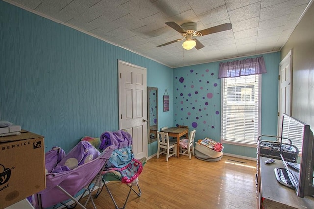 game room with ornamental molding, baseboards, a ceiling fan, and wood finished floors