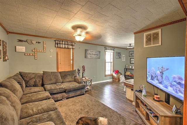 living room with wood finished floors, baseboards, and ornamental molding