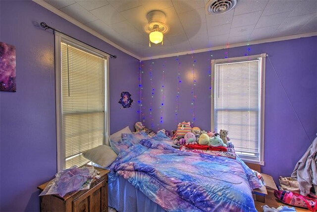 bedroom with visible vents, a ceiling fan, and crown molding