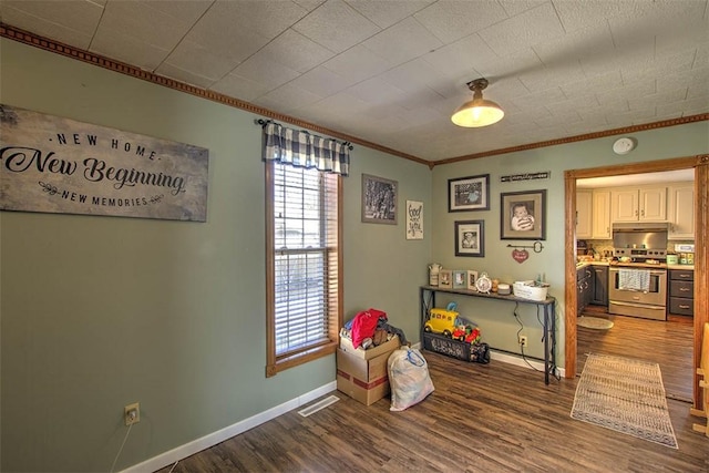 recreation room with visible vents, baseboards, dark wood-style flooring, and ornamental molding