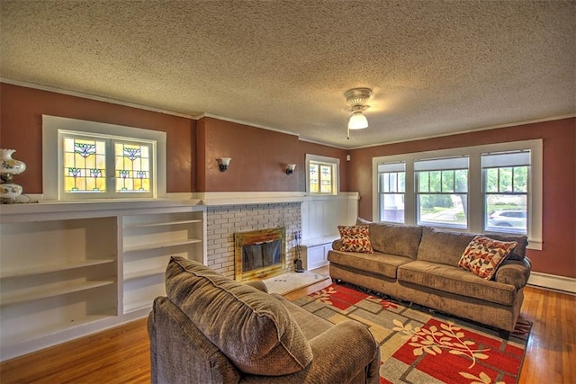 236 N Dennis Ave, Decatur, IL 62522 - living area featuring crown molding, wood finished floors, a textured ceiling, a brick fireplace, and a baseboard heating unit