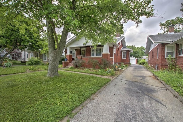 236 N Dennis Ave, Decatur, IL 62522 - view of front of home with brick siding, a front yard, a porch, a garage, and an outdoor structure