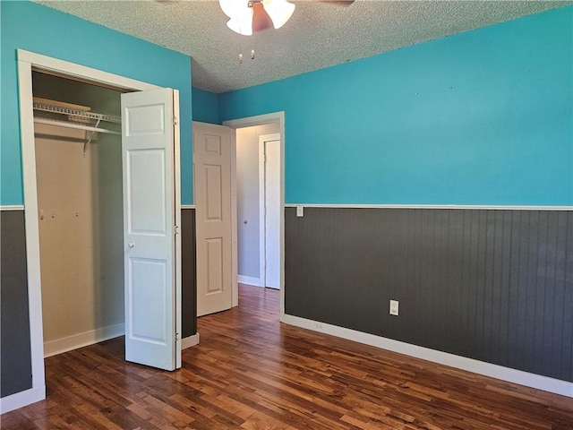 241 S Main St, Argenta, IL 62501 - unfurnished bedroom with wood finished floors, a closet, a textured ceiling, ceiling fan, and a wainscoted wall