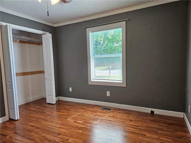241 S Main St, Argenta, IL 62501 - unfurnished bedroom featuring wood finished floors, crown molding, a closet, and a textured ceiling