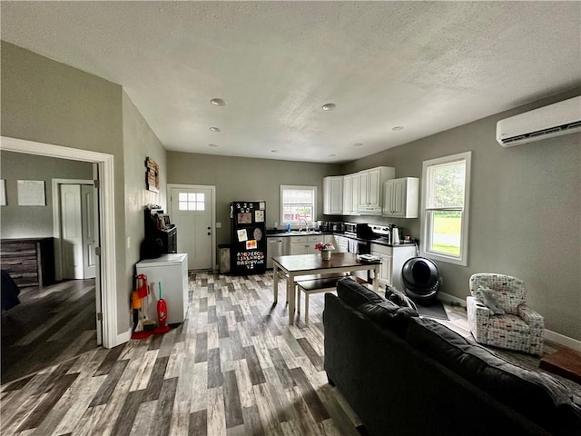 302 E Van Buren St, Paris, IL 61944 - living room with wood finished floors, a wall mounted air conditioner, and a textured ceiling