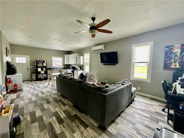 302 E Van Buren St, Paris, IL 61944 - living room featuring a wall mounted air conditioner, ceiling fan, a textured ceiling, and light wood finished floors