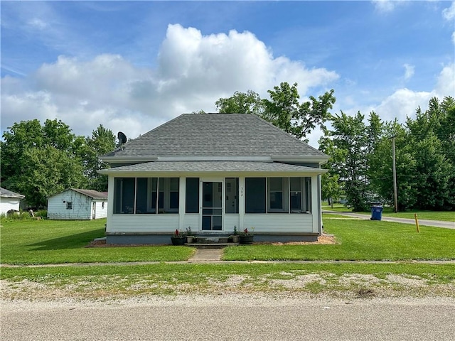 302 E Van Buren St, Paris, IL 61944 - bungalow with a shingled roof, a sunroom, and a front lawn