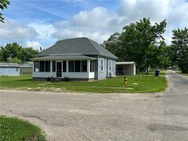 302 E Van Buren St, Paris, IL 61944 - bungalow-style home featuring a sunroom, roof with shingles, a front lawn, and a carport
