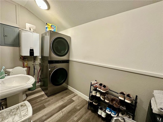 302 E Van Buren St, Paris, IL 61944 - bathroom with water heater, estacked washer and dryer, wood finished floors, a textured ceiling, and vaulted ceiling