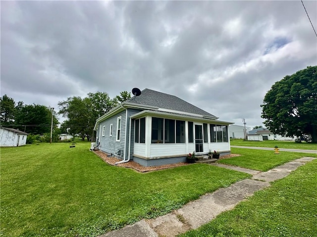 302 E Van Buren St, Paris, IL 61944 - rear view of house with a sunroom, a lawn, and a shingled roof