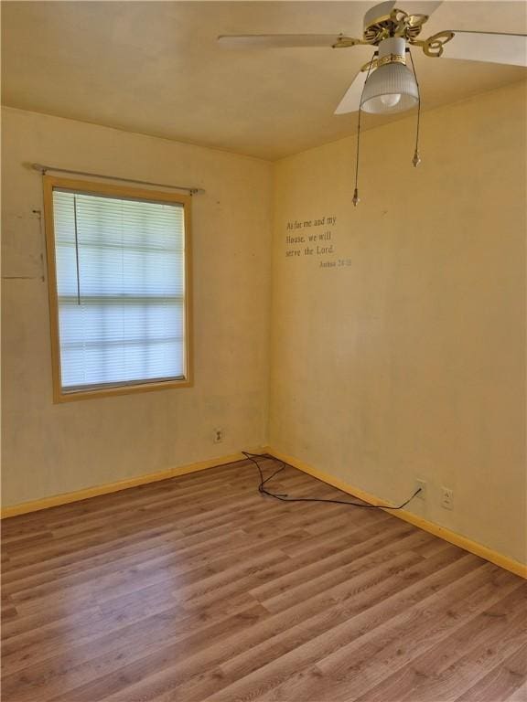 spare room with baseboards, a ceiling fan, and wood finished floors