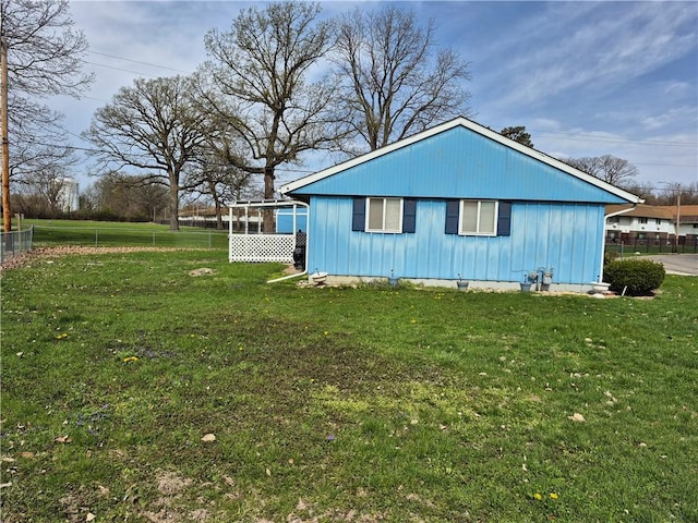 view of side of property featuring fence and a yard